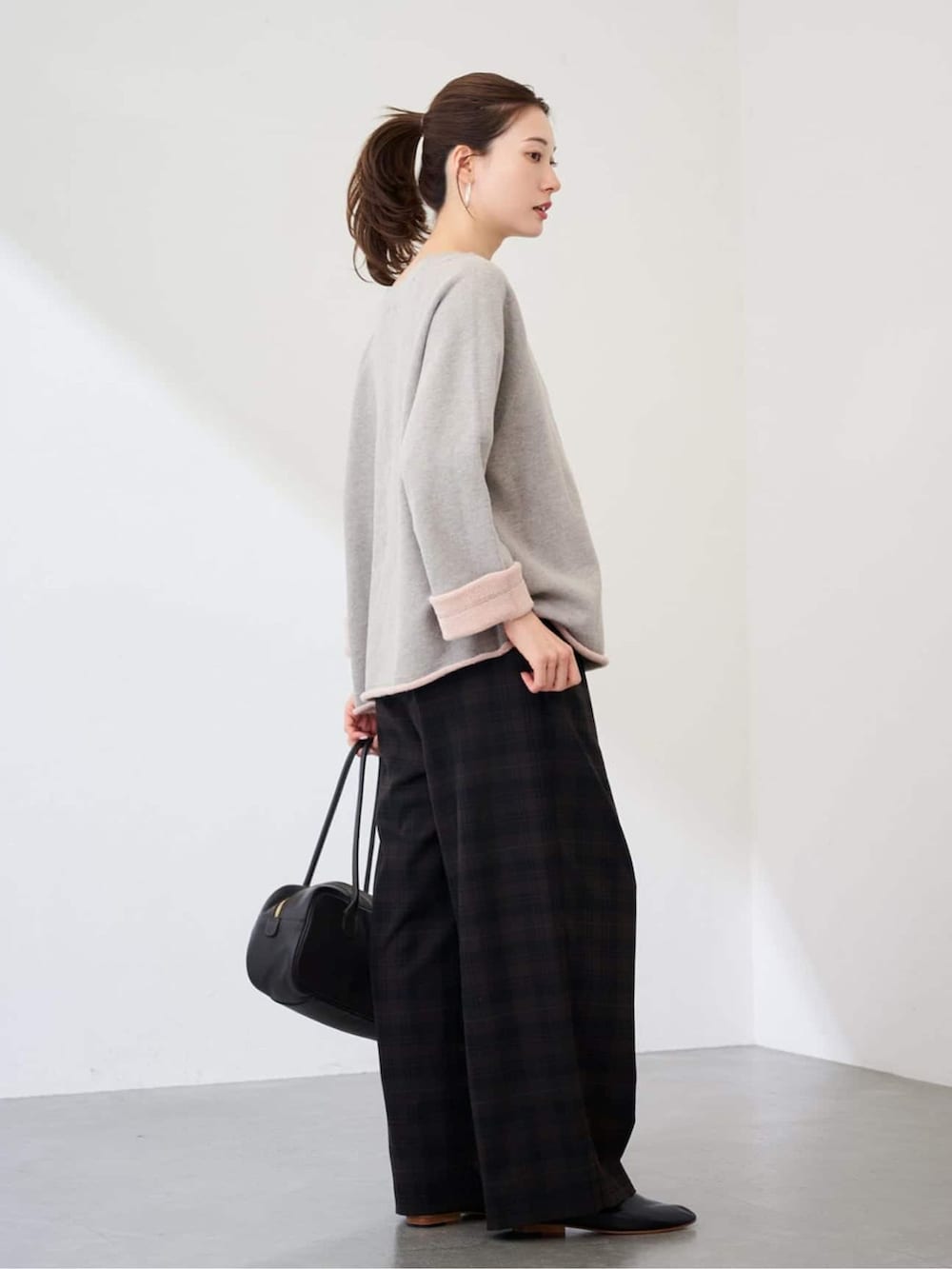 ブラウン系のその他パンツ、グレー系のスウェット、ブラック系のボストンバッグを着用したレディースの冬コーディネートの2枚目の写真