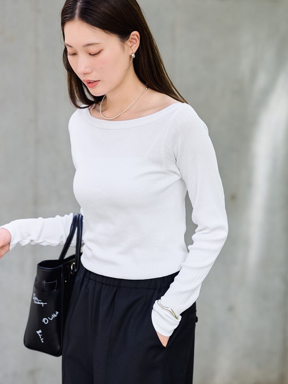 ブラック系のスラックス、ホワイト系のTシャツ/カットソー、ブラック系のショルダーバッグを着用したレディースの夏コーディネートの6枚目の写真