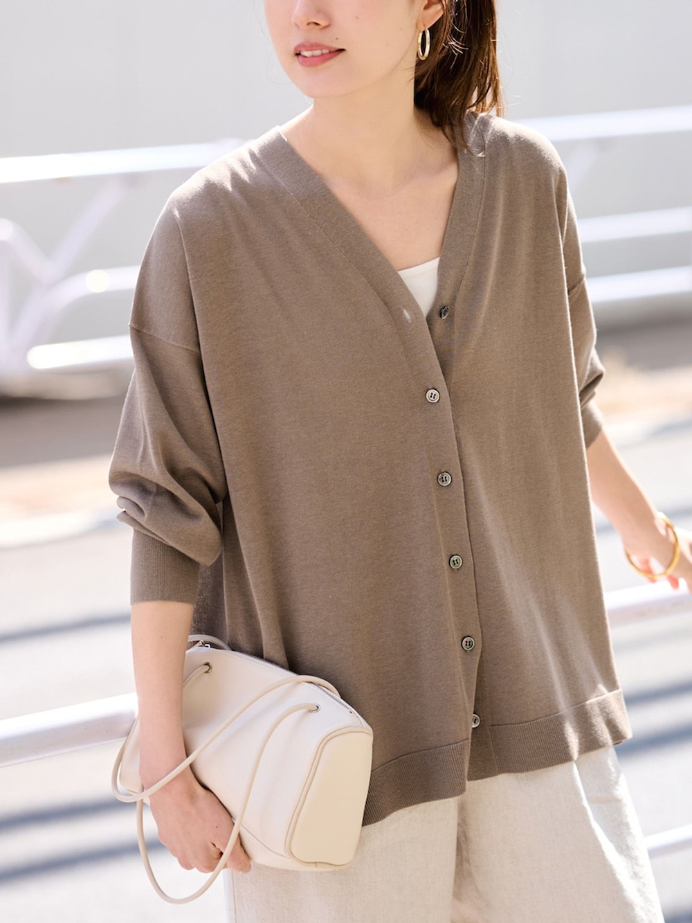 ベージュ系のその他パンツ、ブラウン系のカーディガン/ボレロ、ホワイト系のボストンバッグを着用したレディースの春コーディネートの5枚目の写真