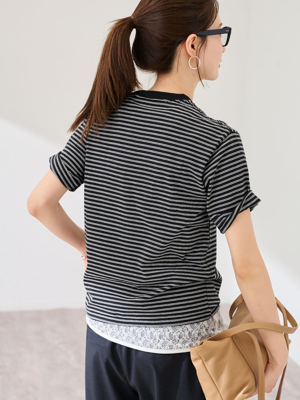 ブラック系のスラックス、ブラック系のTシャツ/カットソーを着用したレディースの春コーディネートの6枚目の写真