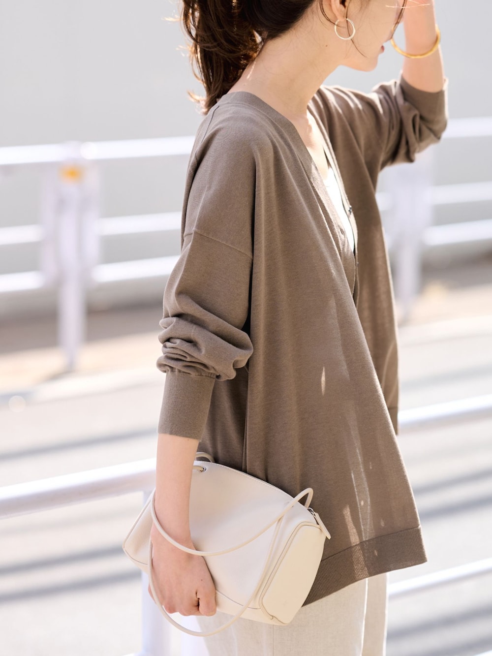 ベージュ系のその他パンツ、ブラウン系のカーディガン/ボレロ、ホワイト系のボストンバッグを着用したレディースの春コーディネートの7枚目の写真