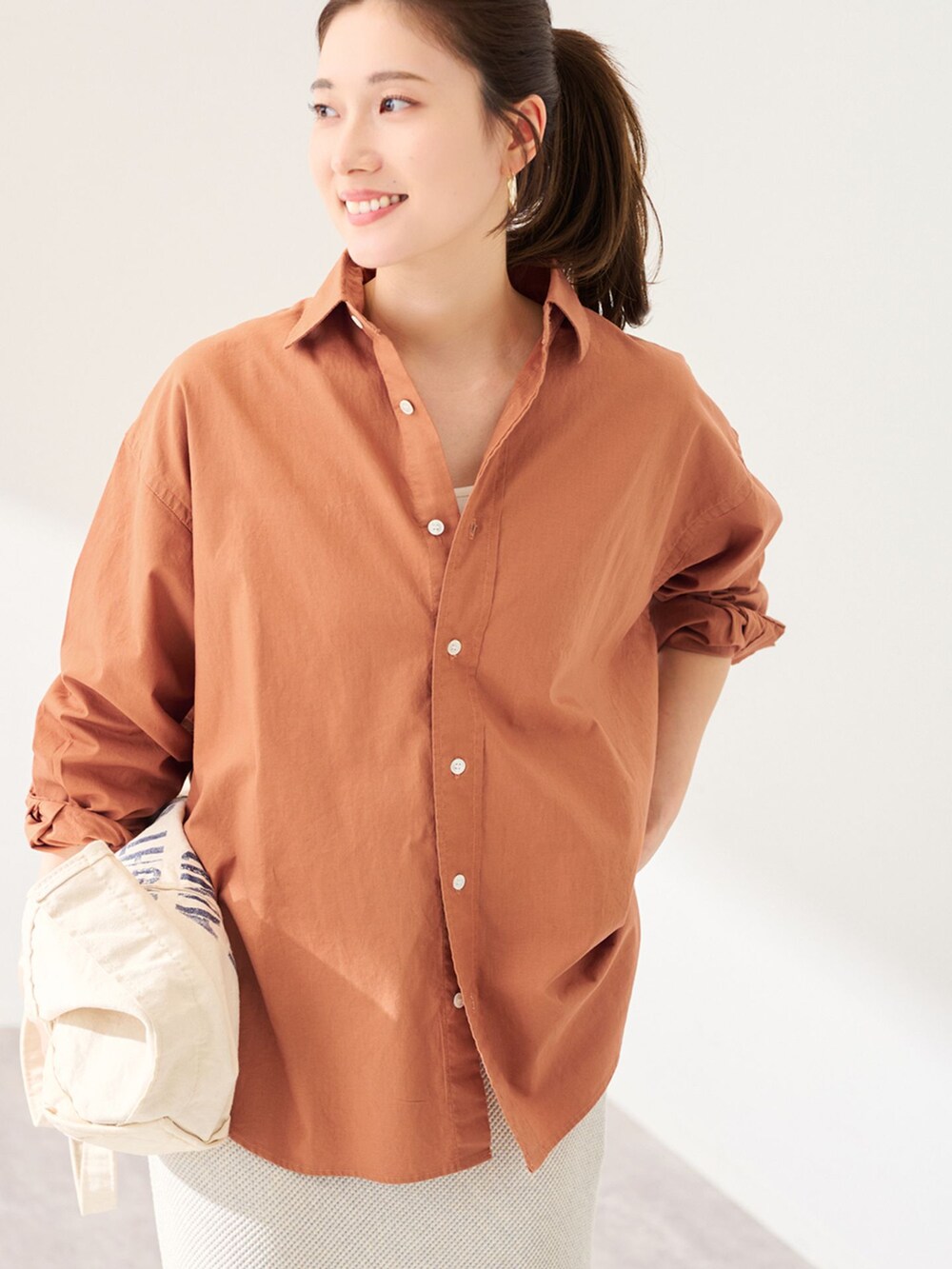 ブラウン系のシャツ/ブラウス、グレー系のスカート、ホワイト系のトートバッグを着用したレディースの冬コーディネートの3枚目の写真