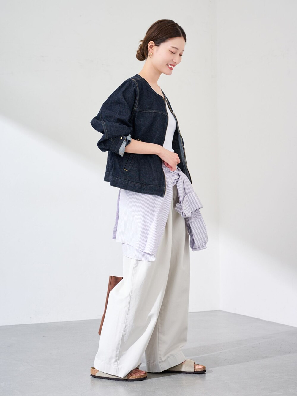 ブルー系のデニムジャケット、パープル系のシャツ/ブラウス、ブラウン系のトートバッグを着用したレディースの夏コーディネートの3枚目の写真