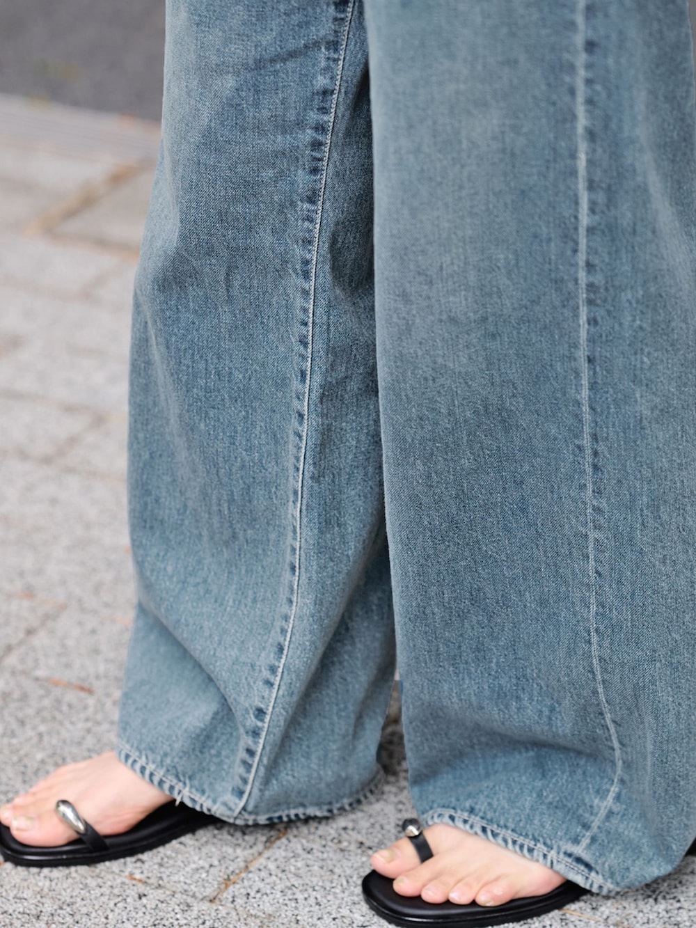 ブルー系のデニムパンツ、グレー系のベスト、ブラック系のハンドバッグを着用したレディースの夏コーディネートの9枚目の写真