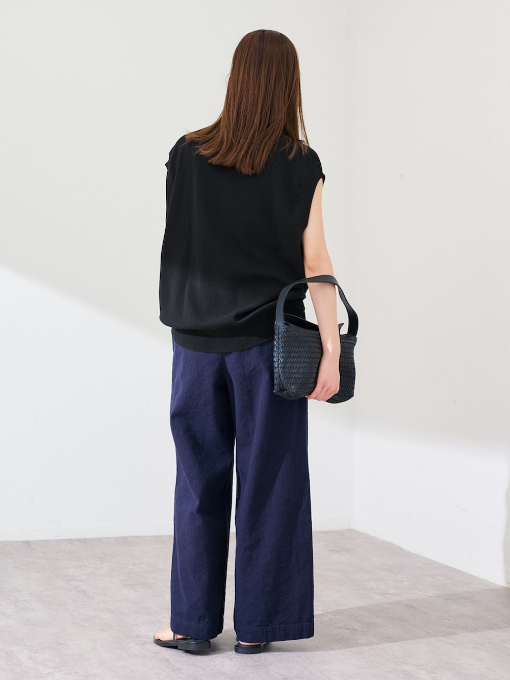 ブルー系のその他パンツ、ブラック系のTシャツ/カットソー、ブラック系のハンドバッグを着用したレディースの春コーディネートの3枚目の写真