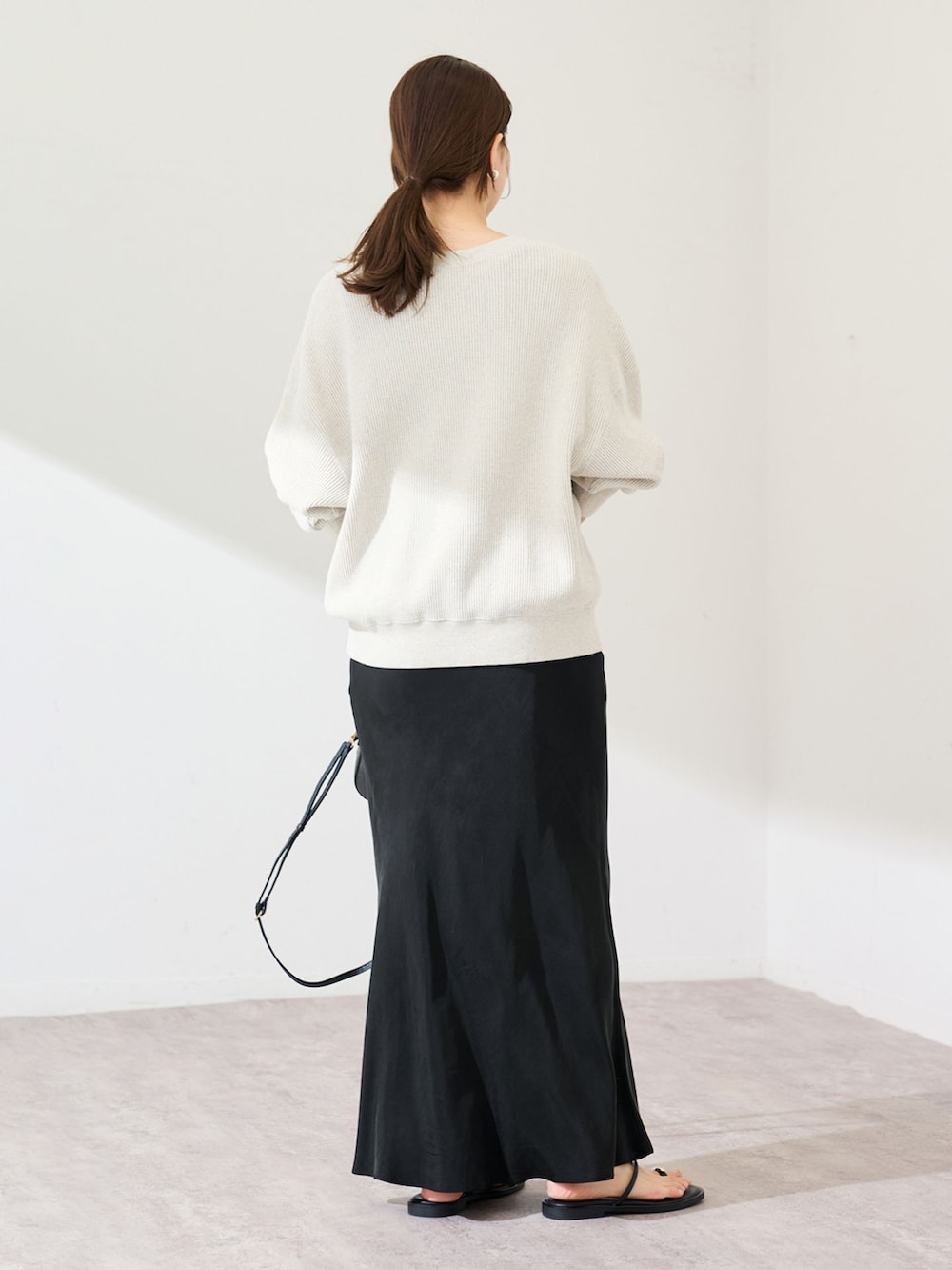 ブラック系のスカート、ホワイト系のTシャツ/カットソーを着用したレディースの冬コーディネートの3枚目の写真