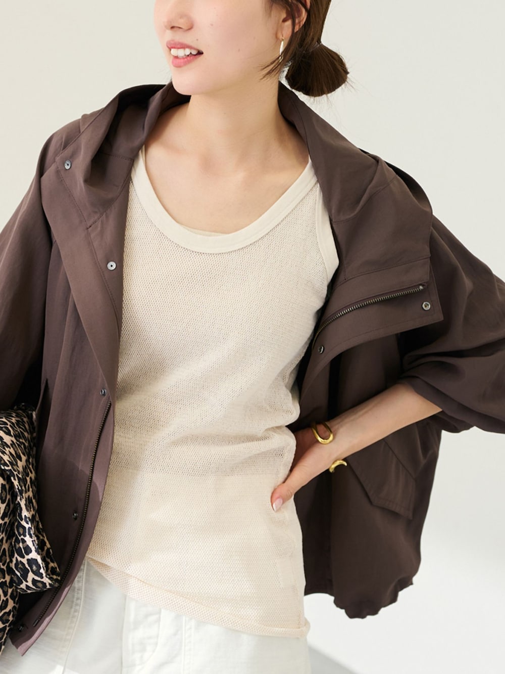 ホワイト系のカーゴパンツ、ブラウン系のマウンテンパーカー、ホワイト系のタンクトップを着用したレディースの冬コーディネートの3枚目の写真