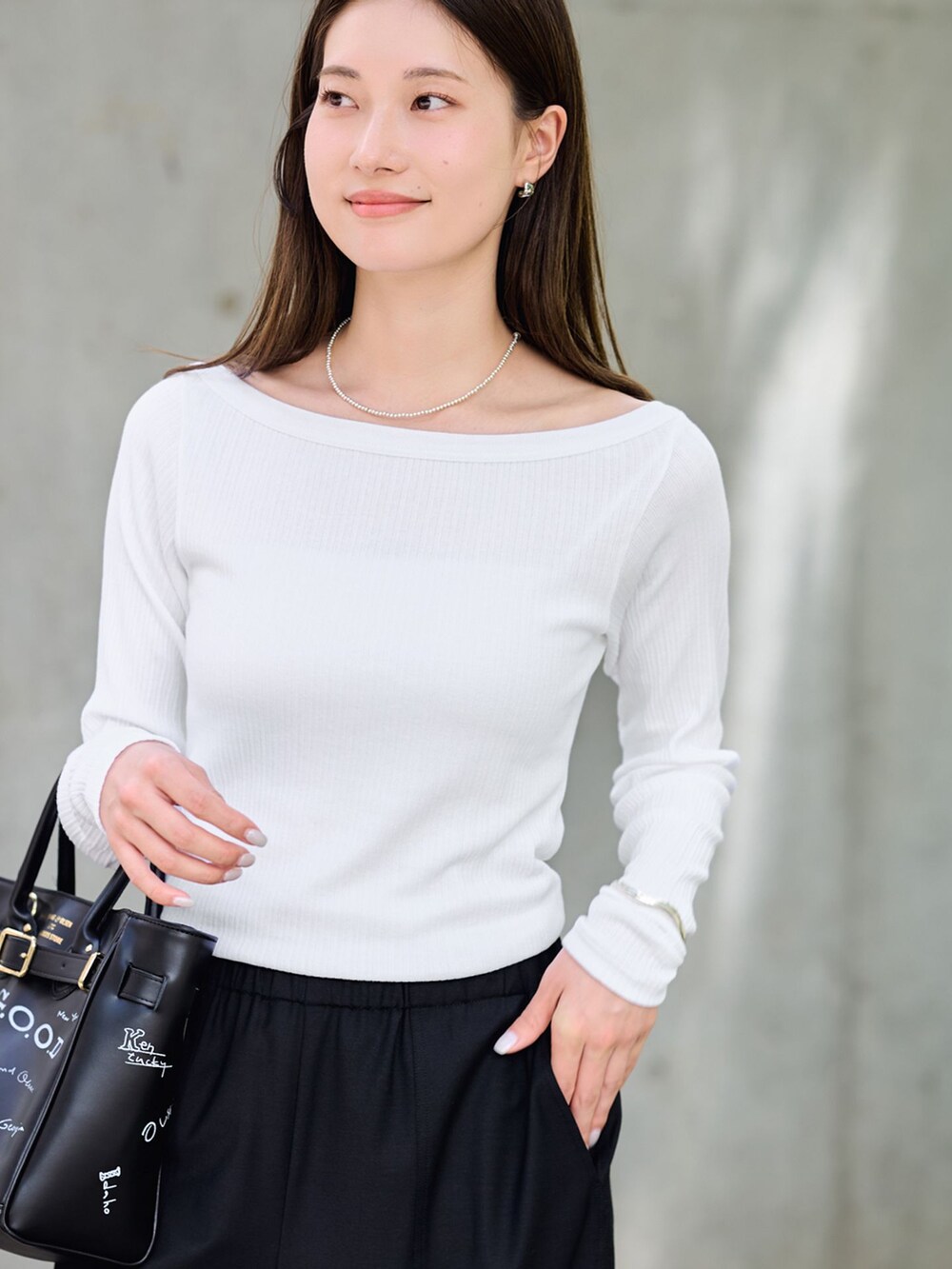 ブラック系のスラックス、ホワイト系のTシャツ/カットソー、ブラック系のショルダーバッグを着用したレディースの夏コーディネートの4枚目の写真