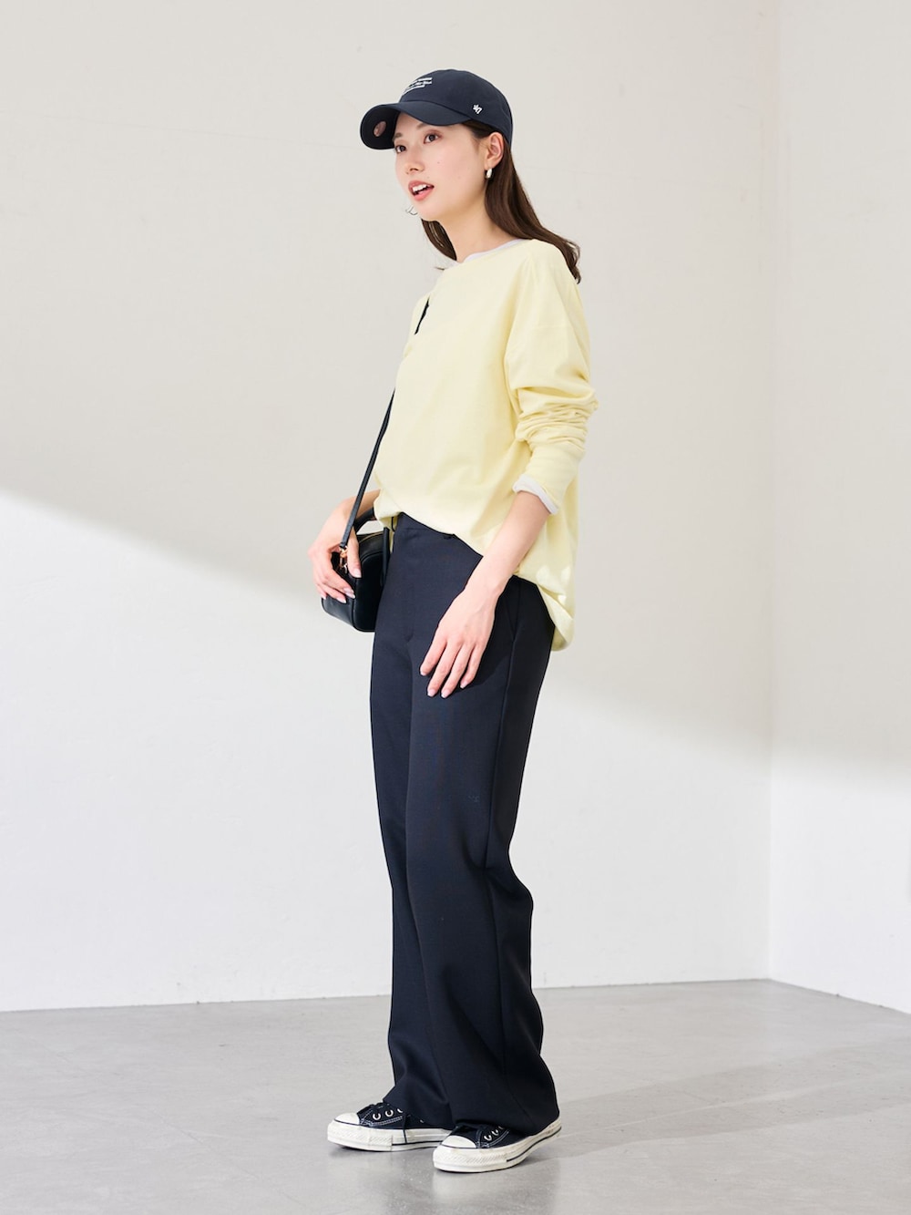 ブラック系のスラックス、イエロー系のTシャツ/カットソー、ホワイト系のTシャツ/カットソーを着用したレディースの冬コーディネートの2枚目の写真