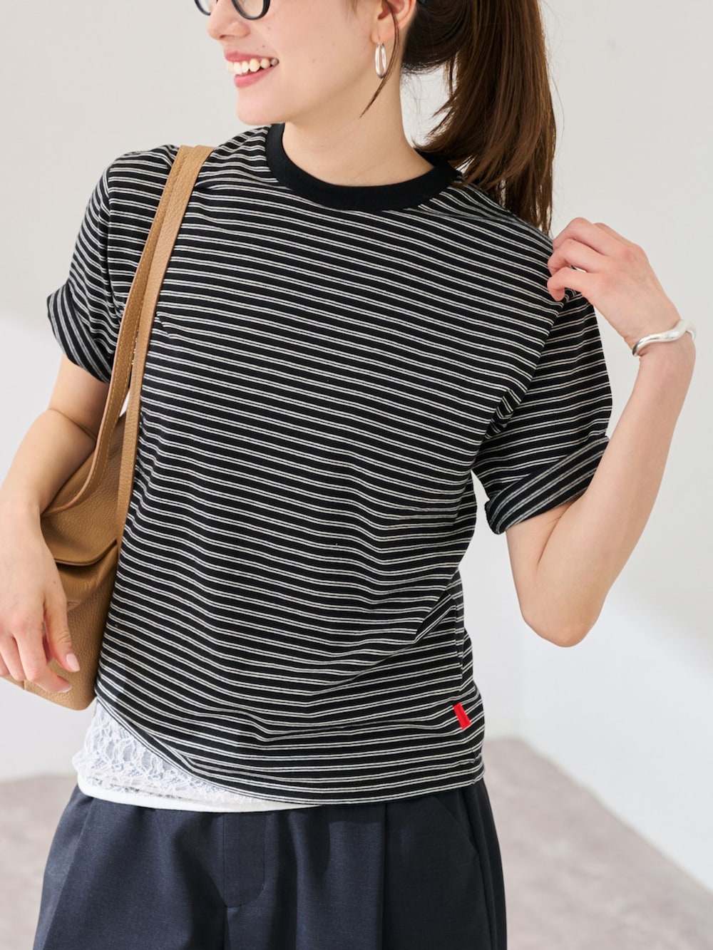 ブラック系のスラックス、ブラック系のTシャツ/カットソーを着用したレディースの春コーディネートの4枚目の写真