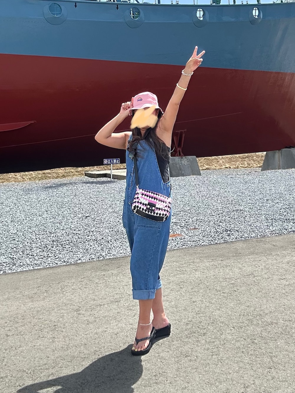 ブラック系のサンダル、ブルー系のサロペット/オーバーオール、ピンク系のショルダーバッグを着用したレディースの夏コーディネートの2枚目の写真