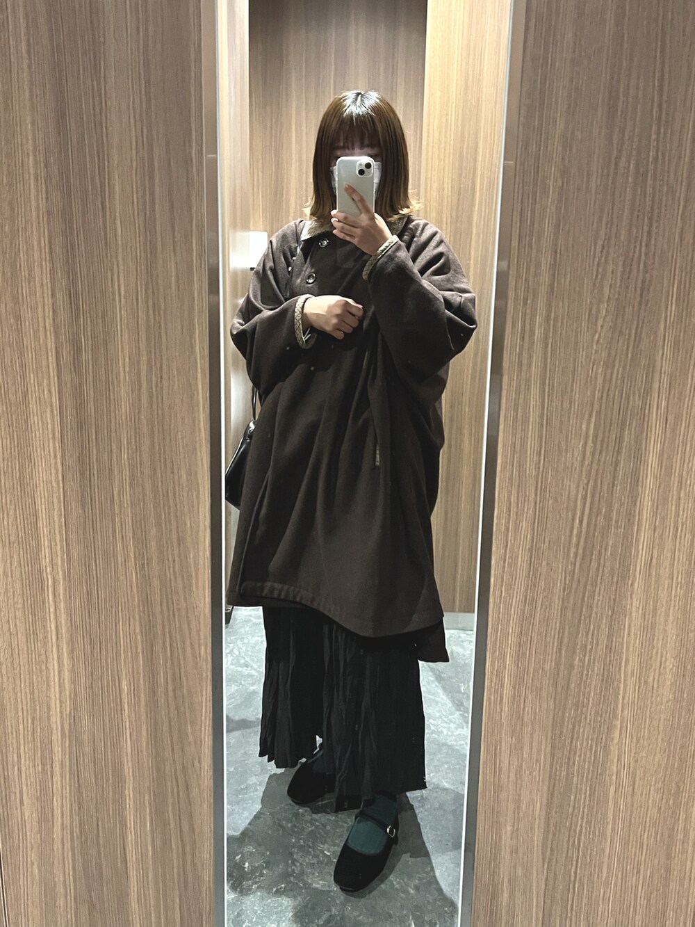 ブラウン系のその他アウター、ブラック系のボストンバッグ、ブラック系のスカートを着用したレディースの冬コーディネートの2枚目の写真