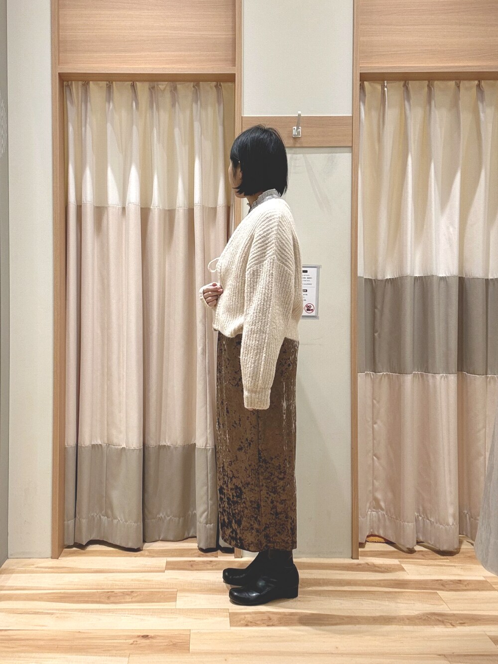 ホワイト系のカーディガン/ボレロ、ブルー系のシャツ/ブラウス、ブラウン系のスカートを着用したレディースの冬コーディネートの2枚目の写真