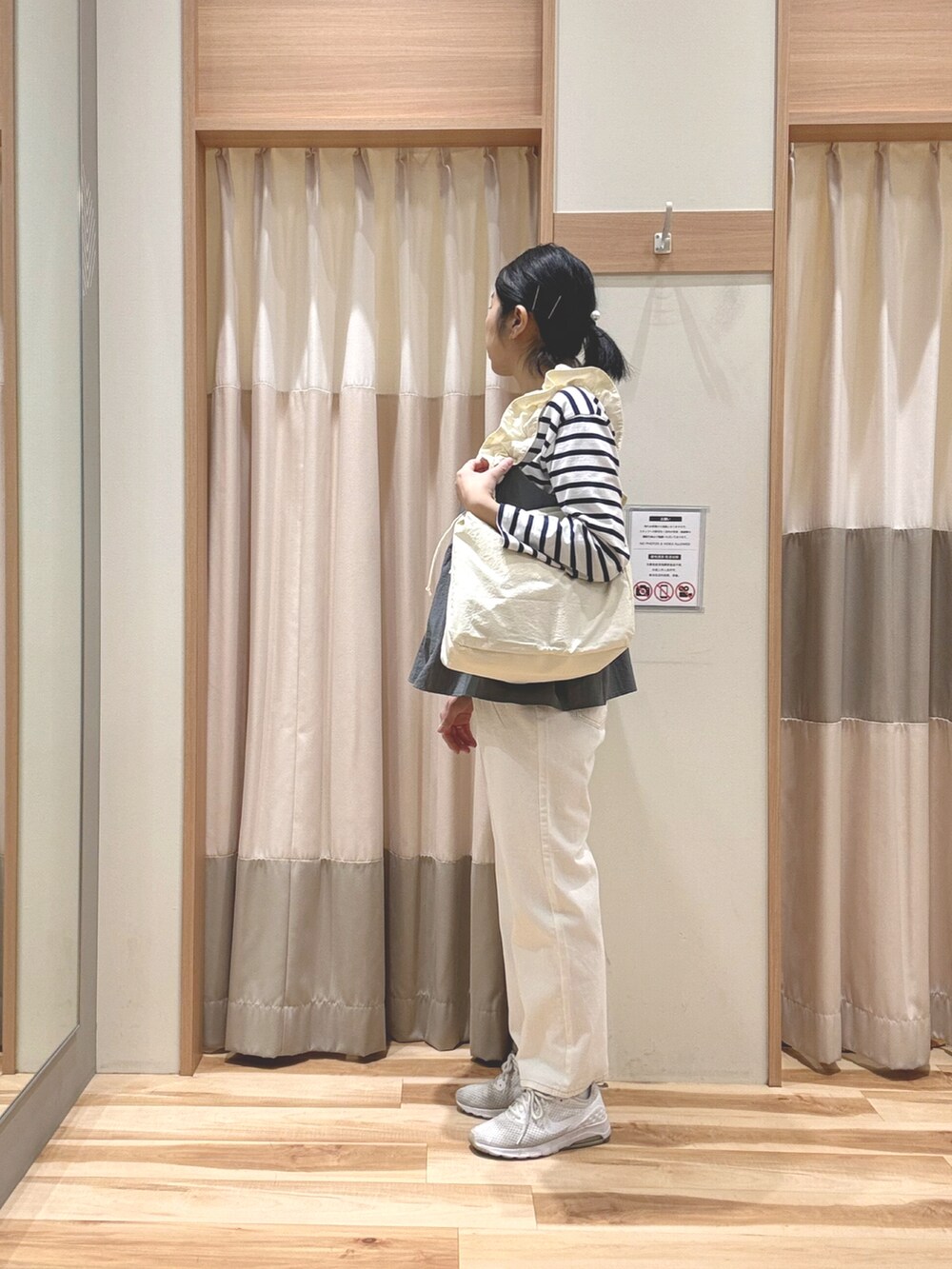 ホワイト系のTシャツ/カットソー、ホワイト系のハンドバッグ、グレー系のシャツ/ブラウスを着用したレディースの春コーディネートの2枚目の写真