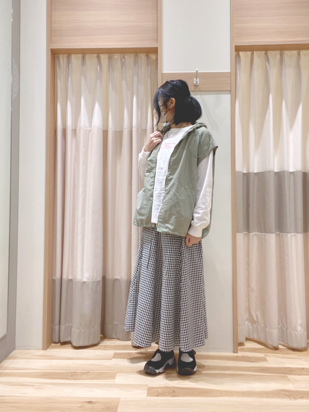 グリーン系のブルゾン、ホワイト系のTシャツ/カットソー、ブラック系のスカートを着用したレディースの春コーディネートの2枚目の写真