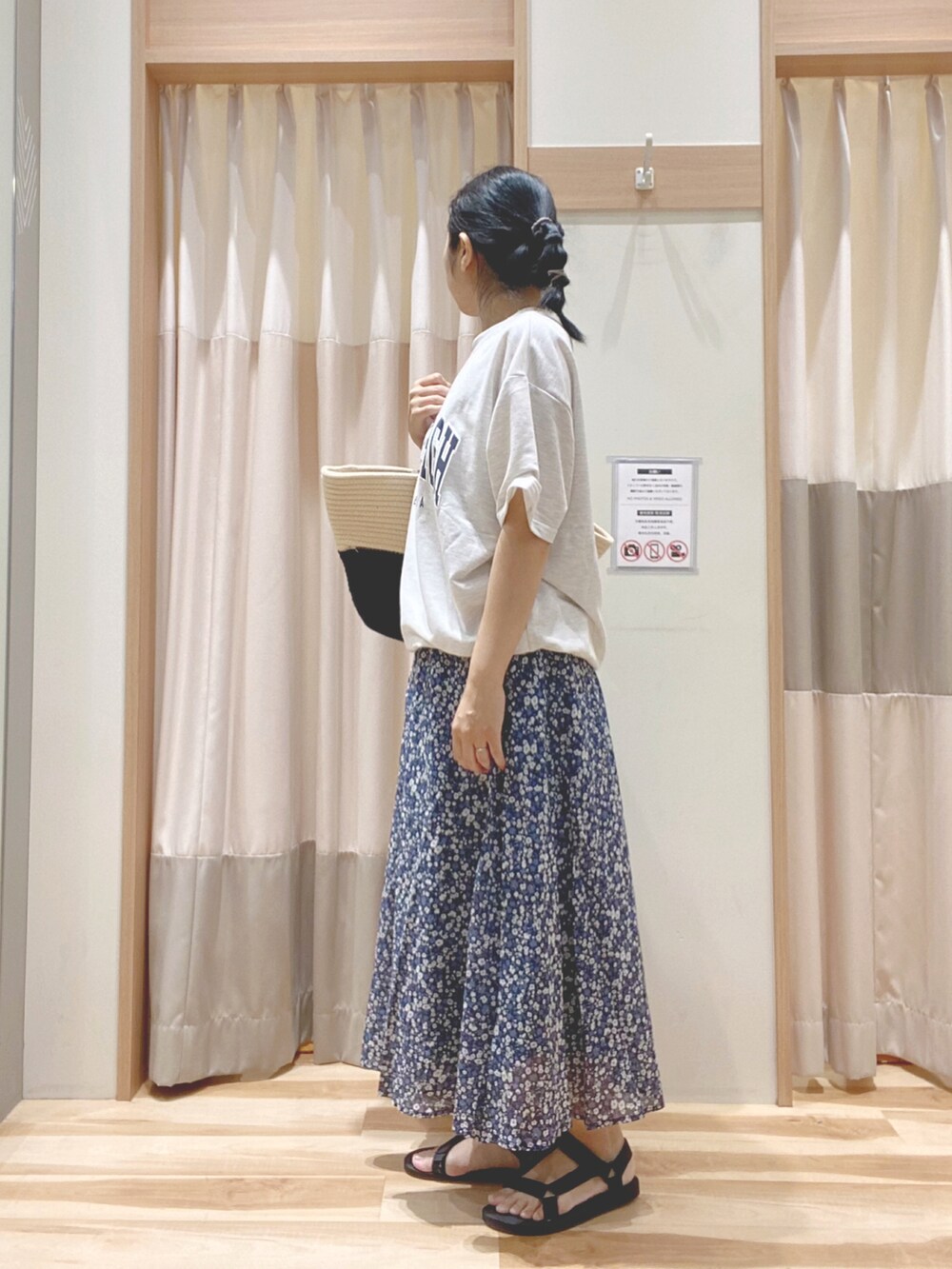 ブルー系のスカート、グレー系のTシャツ/カットソー、ホワイト系のハンドバッグを着用したレディースの夏コーディネートの2枚目の写真