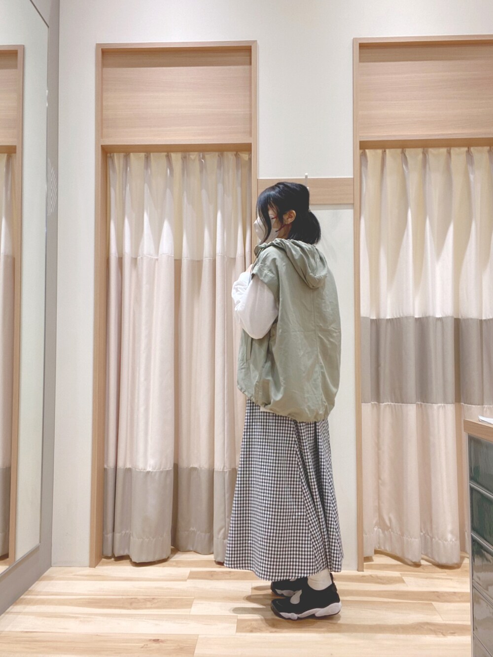 グリーン系のブルゾン、ホワイト系のTシャツ/カットソー、ブラック系のスカートを着用したレディースの春コーディネートの3枚目の写真