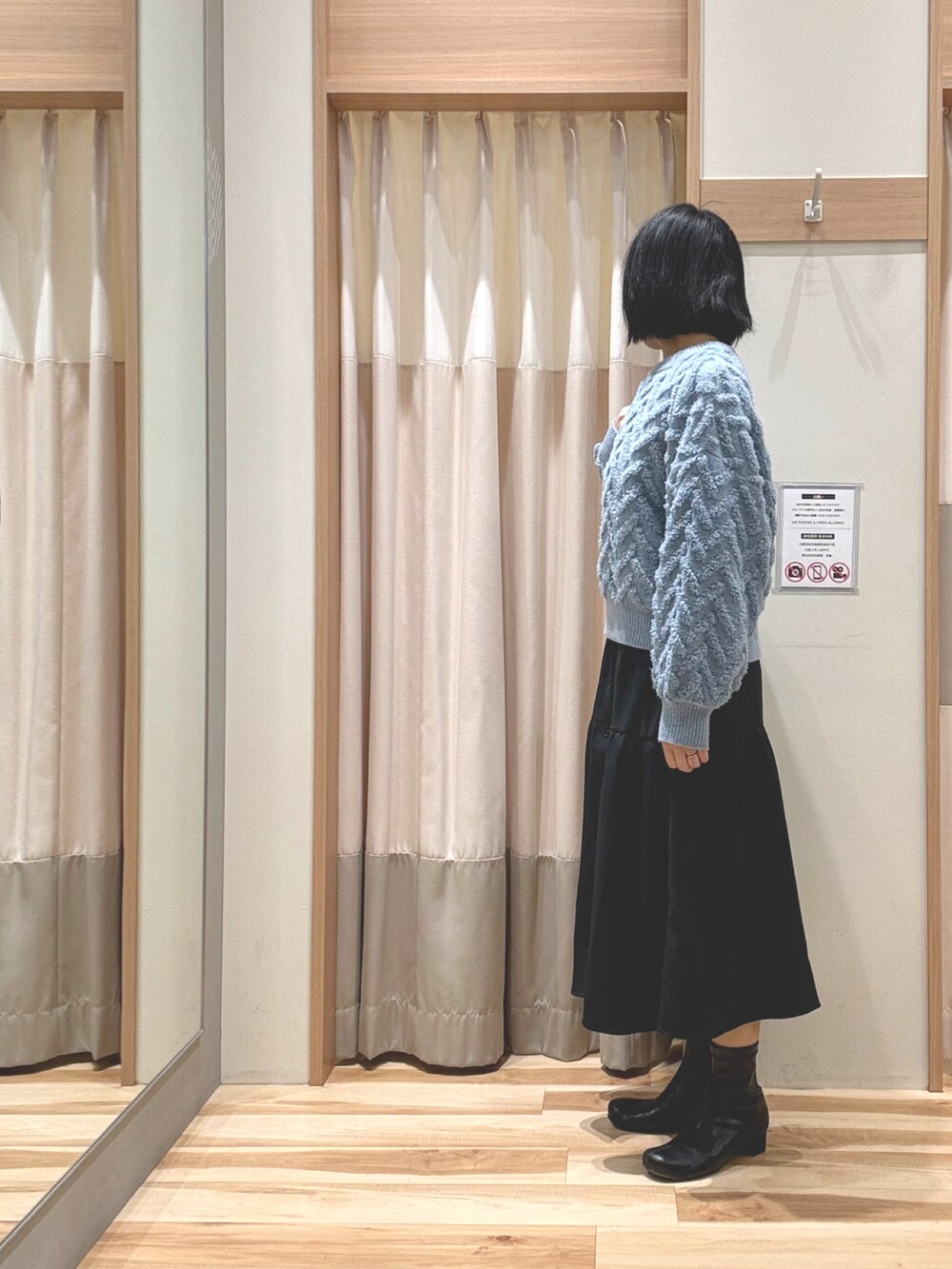 ブルー系のニット/セーター、ブラック系のワンピース、ブラック系のブーツを着用したレディースの冬コーディネートの2枚目の写真