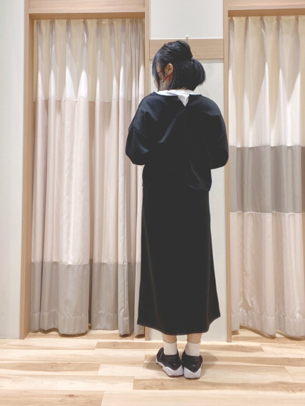 ホワイト系のTシャツ/カットソー、ブラック系のカーディガン/ボレロ、ブラック系のスカートを着用したレディースの春コーディネートの3枚目の写真