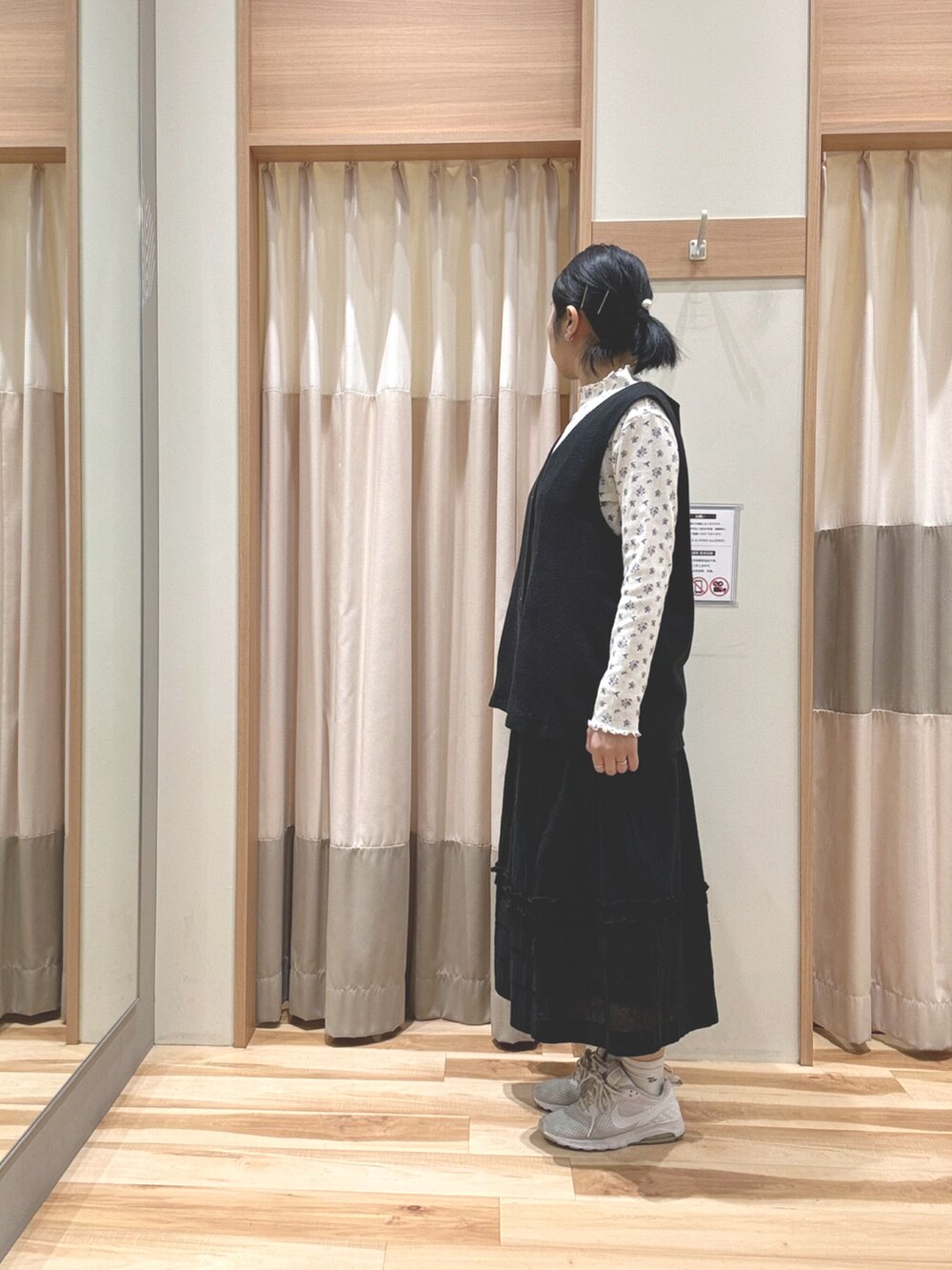 グレー系のベスト、ブルー系のTシャツ/カットソー、ブラック系のスカートを着用したレディースの春コーディネートの2枚目の写真