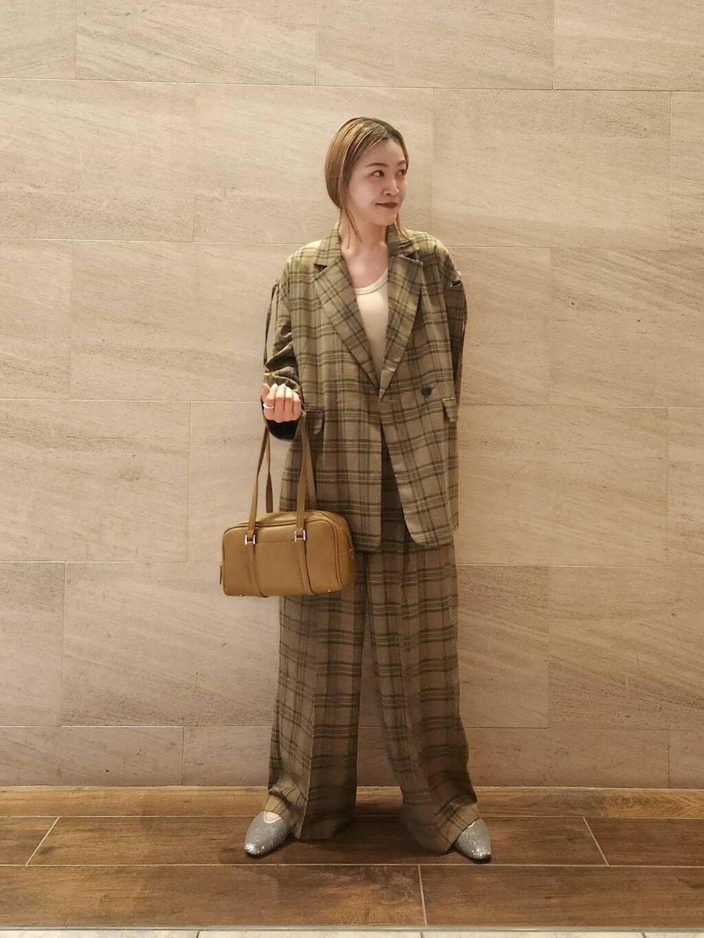 シルバー系のパンプス、グリーン系のボストンバッグ、グリーン系のテーラードジャケットを着用したレディースの夏コーディネートの3枚目の写真