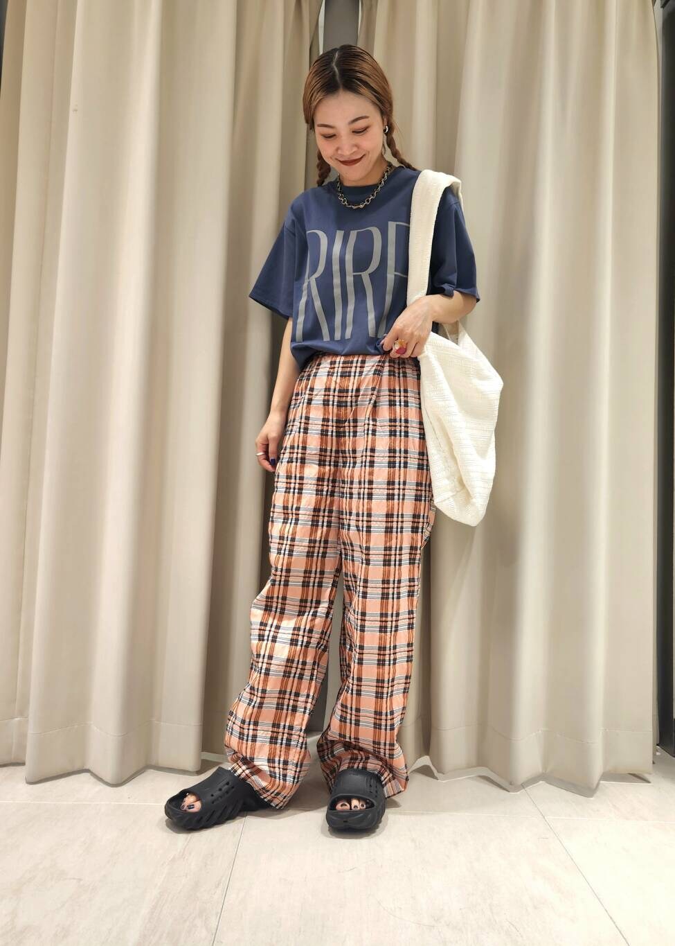 ホワイト系のショルダーバッグ、オレンジ系のその他パンツ、ブルー系のTシャツ/カットソーを着用したレディースの夏コーディネートの3枚目の写真