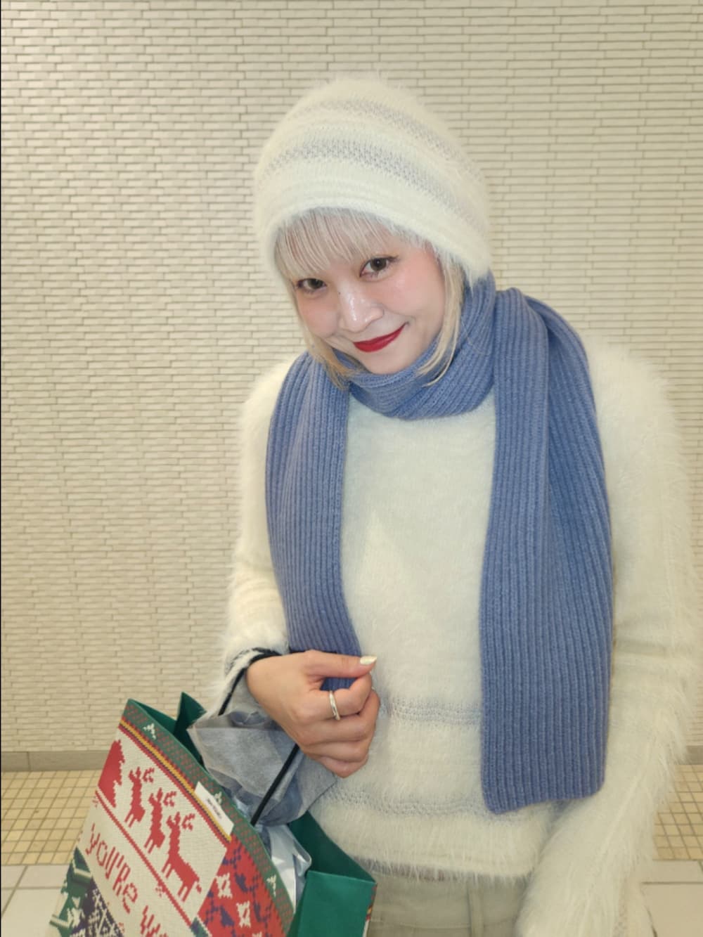 ホワイト系のニット/セーター、ベージュ系のその他パンツ、ブルー系のマフラーを着用したレディースの秋コーディネートの4枚目の写真