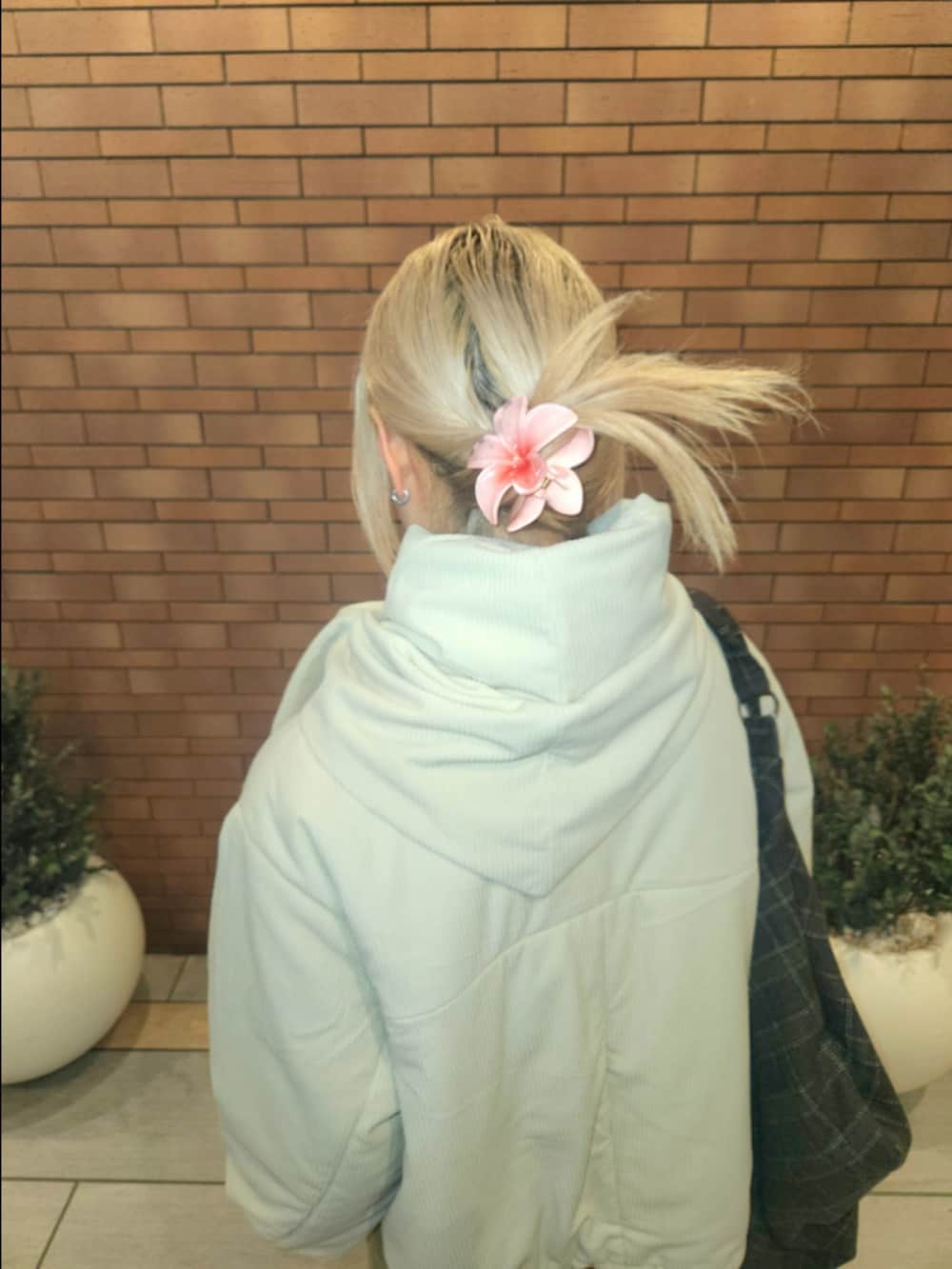 ブラウン系のトートバッグ、ホワイト系のその他アウター、ベージュ系のその他パンツを着用したレディースの秋コーディネートの3枚目の写真