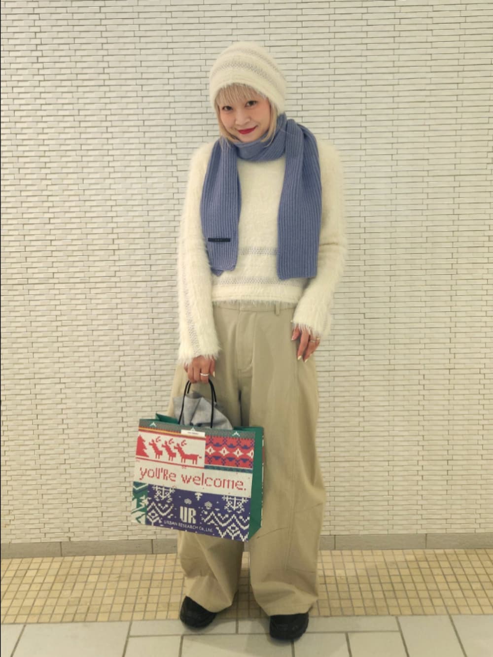 ホワイト系のニット/セーター、ベージュ系のその他パンツ、ブルー系のマフラーを着用したレディースの秋コーディネートの2枚目の写真