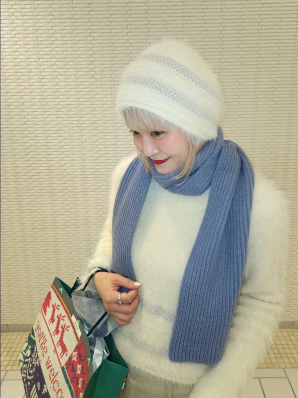 ホワイト系のニット/セーター、ベージュ系のその他パンツ、ブルー系のマフラーを着用したレディースの秋コーディネートの3枚目の写真