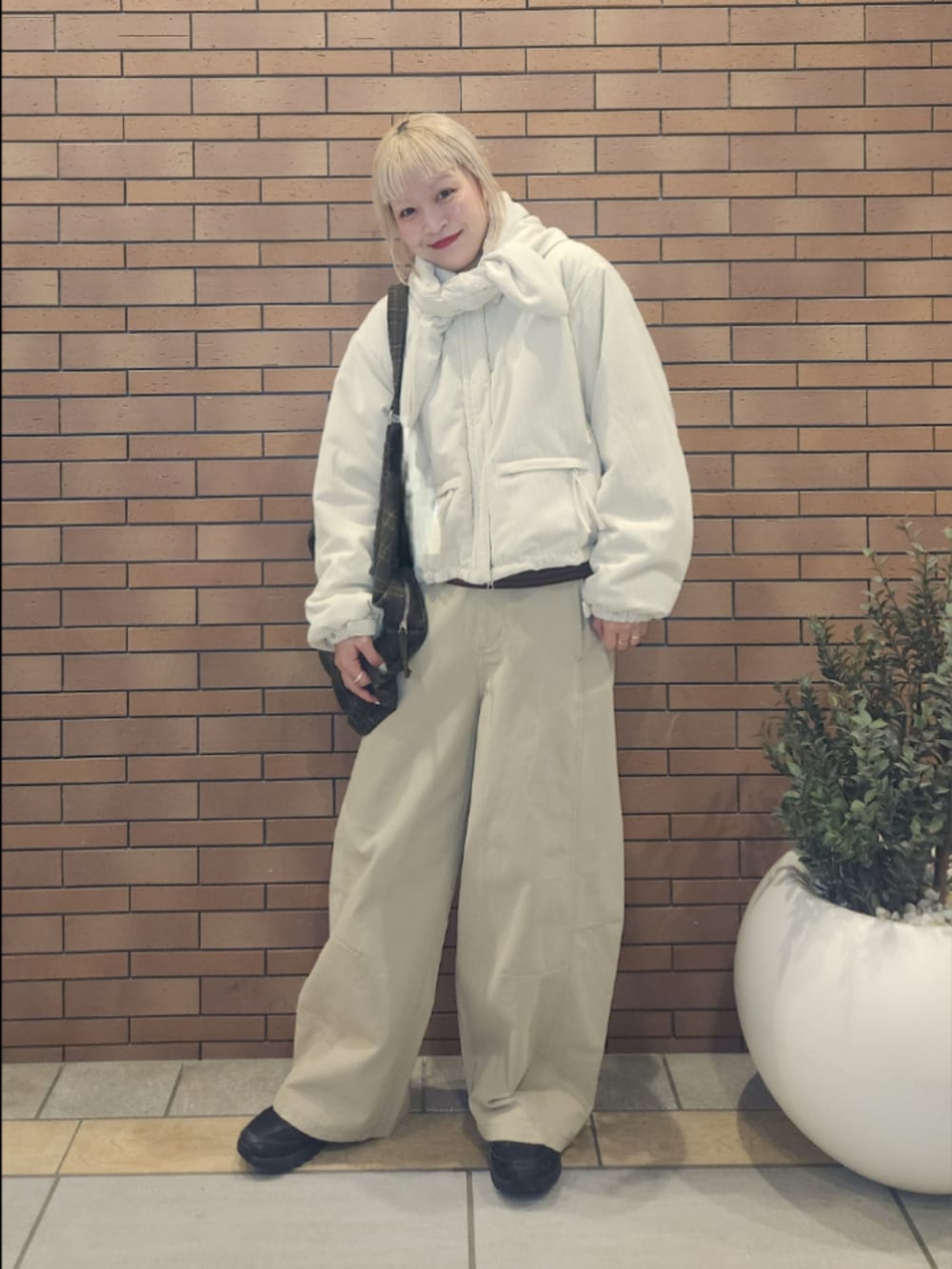 ブラウン系のトートバッグ、ホワイト系のその他アウター、ベージュ系のその他パンツを着用したレディースの秋コーディネートの2枚目の写真