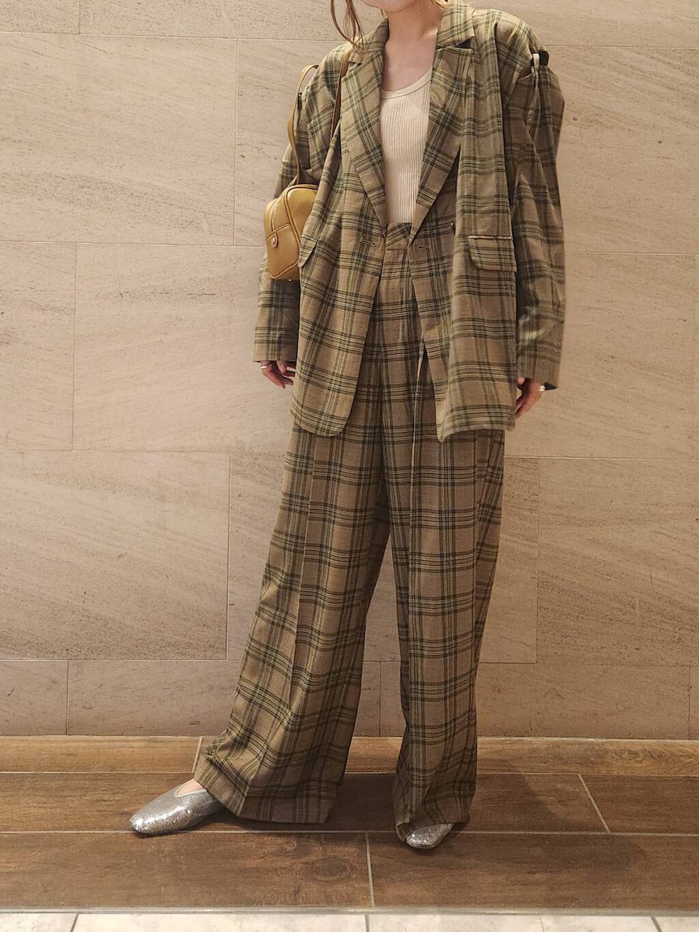 シルバー系のパンプス、グリーン系のボストンバッグ、グリーン系のテーラードジャケットを着用したレディースの夏コーディネートの2枚目の写真