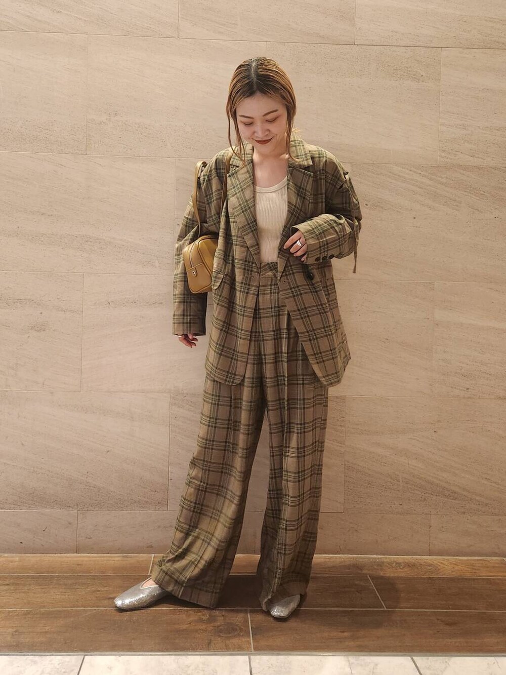 シルバー系のパンプス、グリーン系のボストンバッグ、グリーン系のテーラードジャケットを着用したレディースの夏コーディネートの4枚目の写真