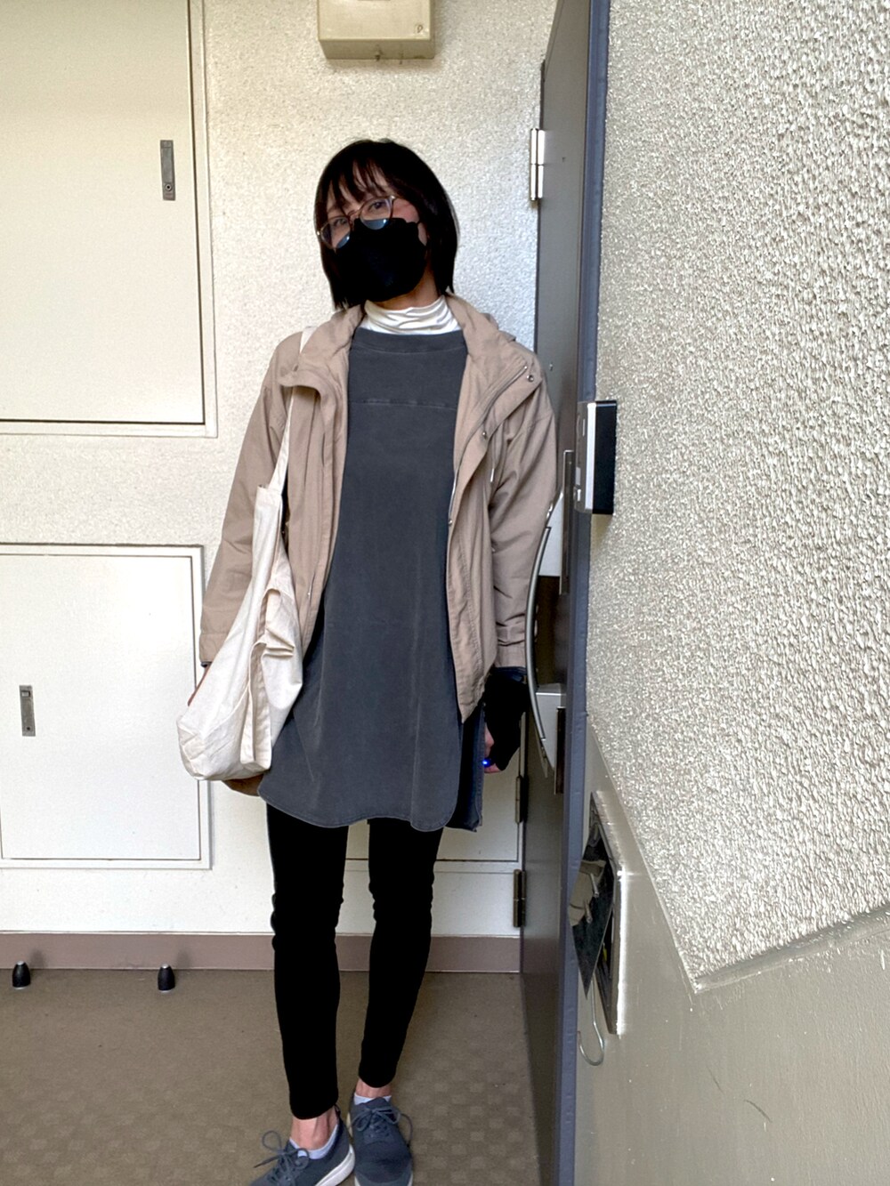 ブルー系のデニムパンツ、グレー系のTシャツ/カットソー、ベージュ系のマウンテンパーカーを着用したレディースの春コーディネートの2枚目の写真