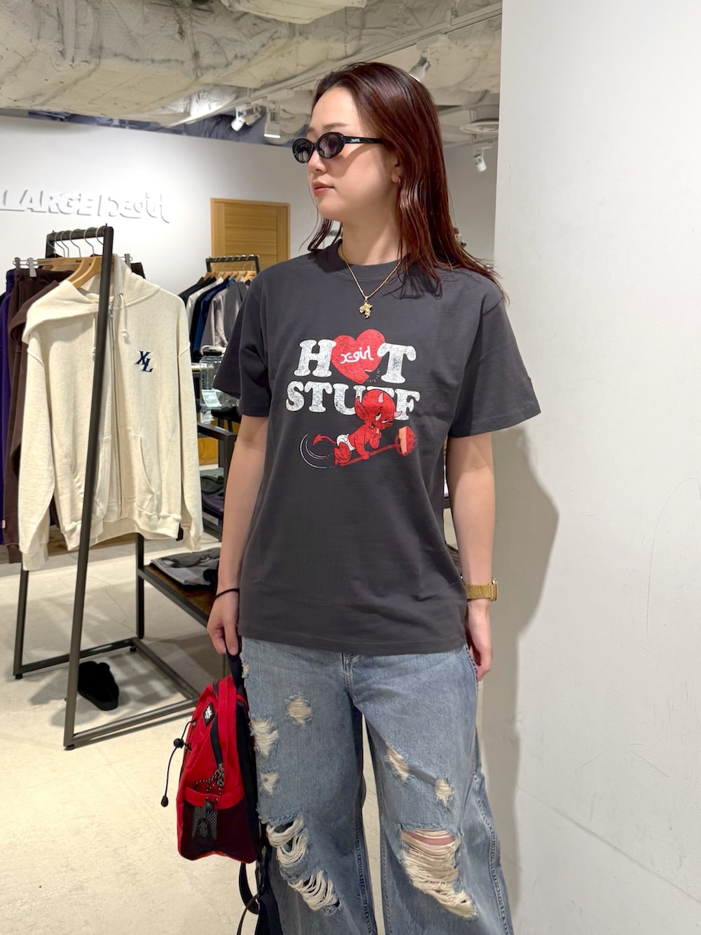 ブルー系のデニムパンツ、ブラック系のTシャツ/カットソー、レッド系のバックパック/リュックを着用したレディースの夏コーディネートの4枚目の写真