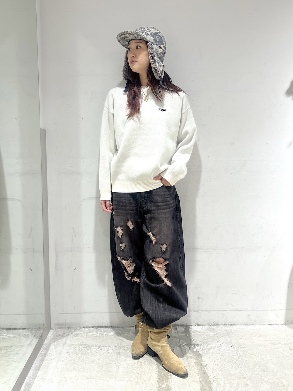 ブラック系のデニムパンツ、ホワイト系のニット/セーター、その他のキャップを着用したレディースの秋コーディネートの4枚目の写真
