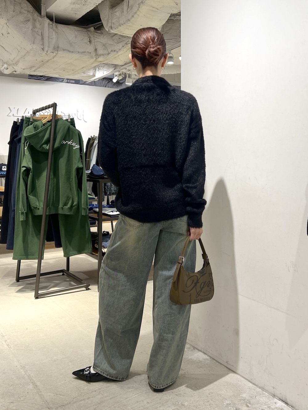 ブラック系のニット/セーター、ブルー系のデニムパンツを着用したレディースの秋コーディネートの3枚目の写真