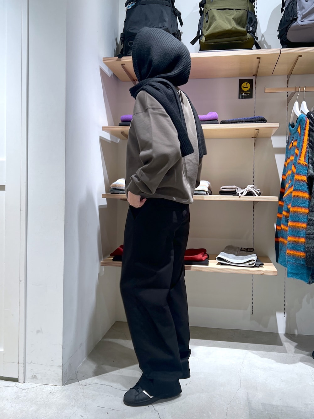 グリーン系のスウェット、ブラック系のその他パンツ、ブルー系のストール/ショールを着用したレディースの冬コーディネートの2枚目の写真