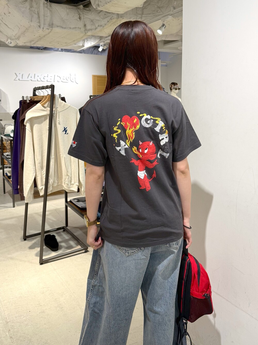 ブルー系のデニムパンツ、ブラック系のTシャツ/カットソー、レッド系のバックパック/リュックを着用したレディースの夏コーディネートの5枚目の写真