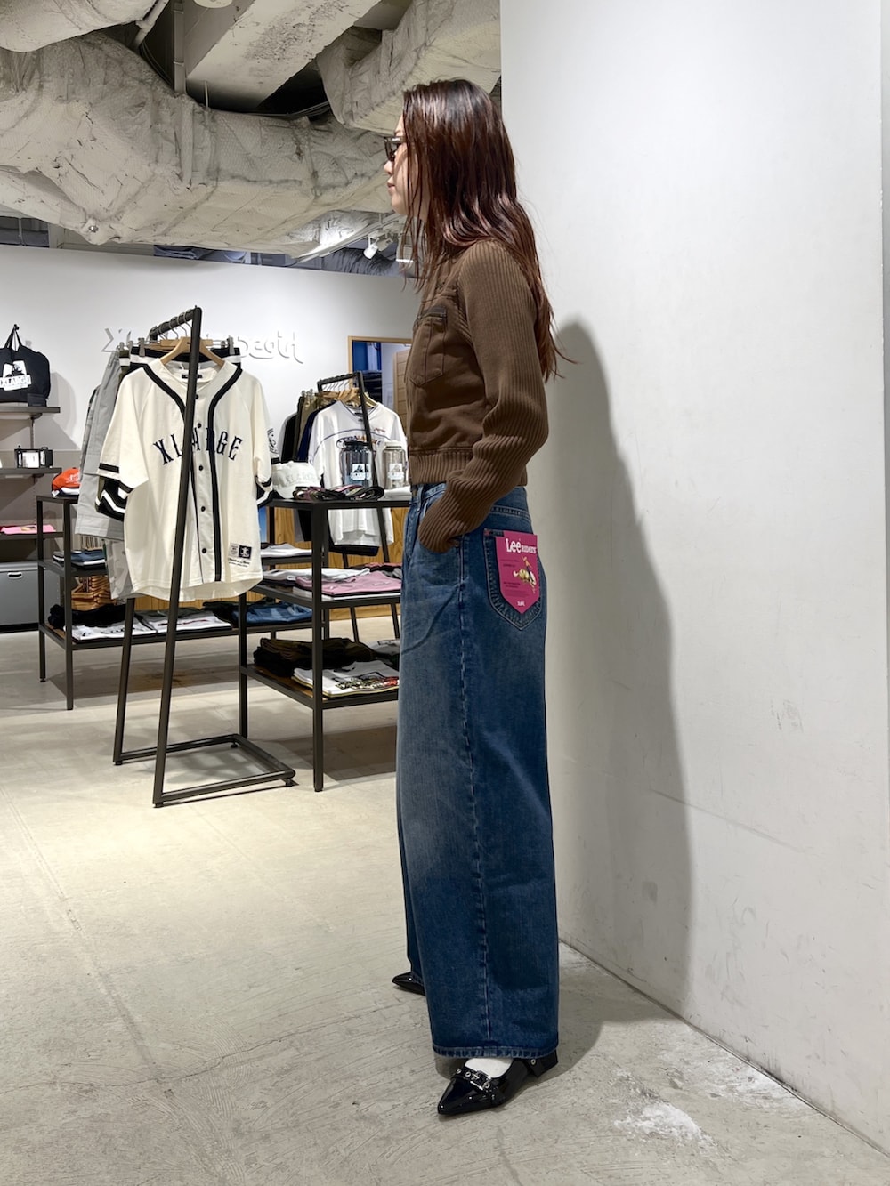 ブルー系のデニムパンツ、ブラウン系のブルゾンを着用したレディースの夏コーディネートの2枚目の写真