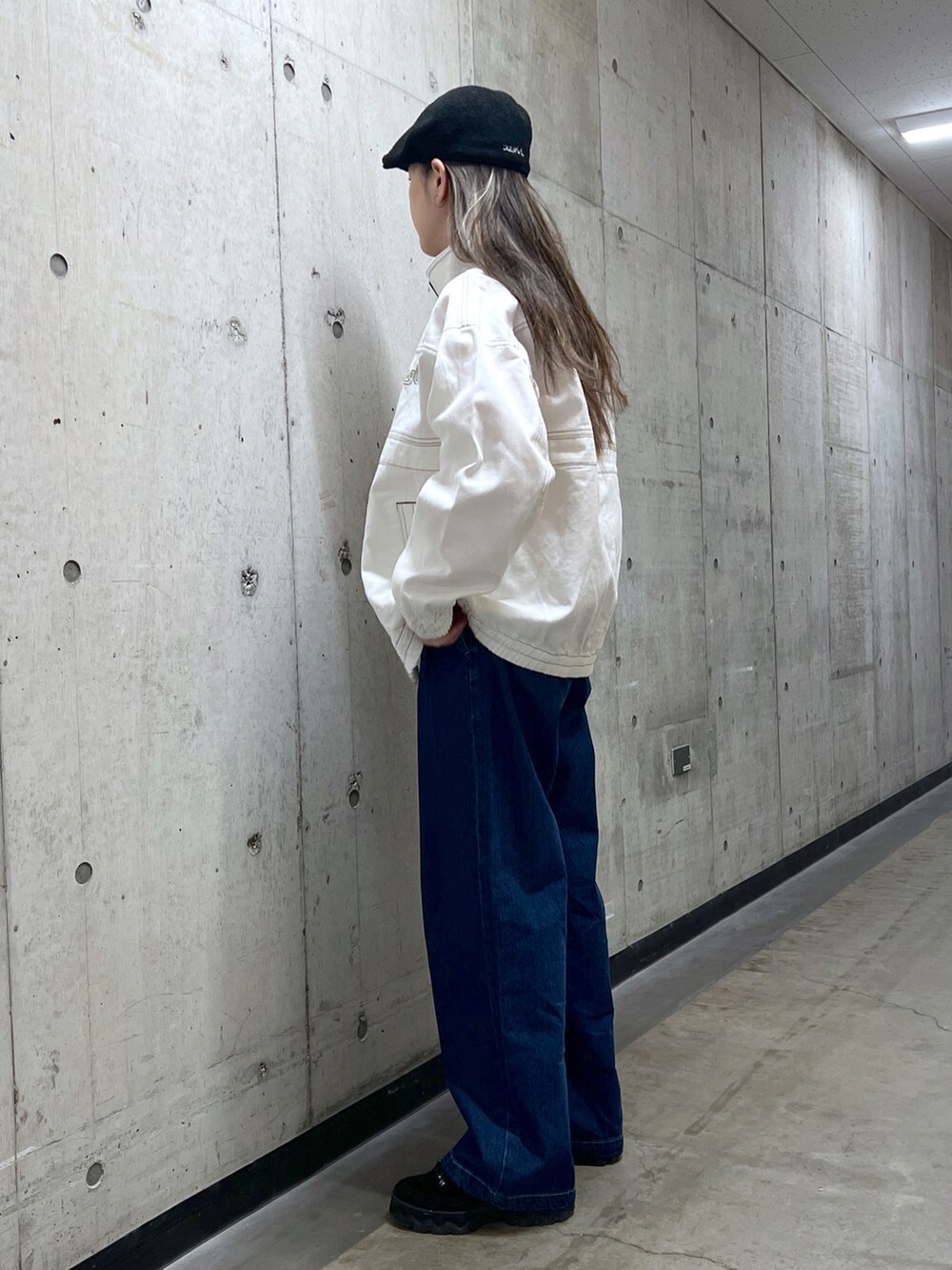 ホワイト系のブルゾン、ピンク系のTシャツ/カットソー、ブルー系のデニムパンツを着用したレディースの冬コーディネートの2枚目の写真