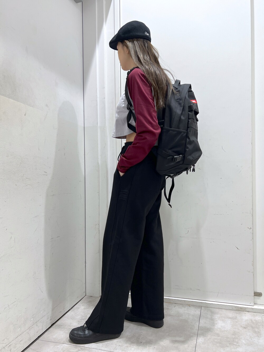 ブラック系のスウェットパンツ、レッド系のパーカー、レッド系のバックパック/リュックを着用したレディースの冬コーディネートの2枚目の写真