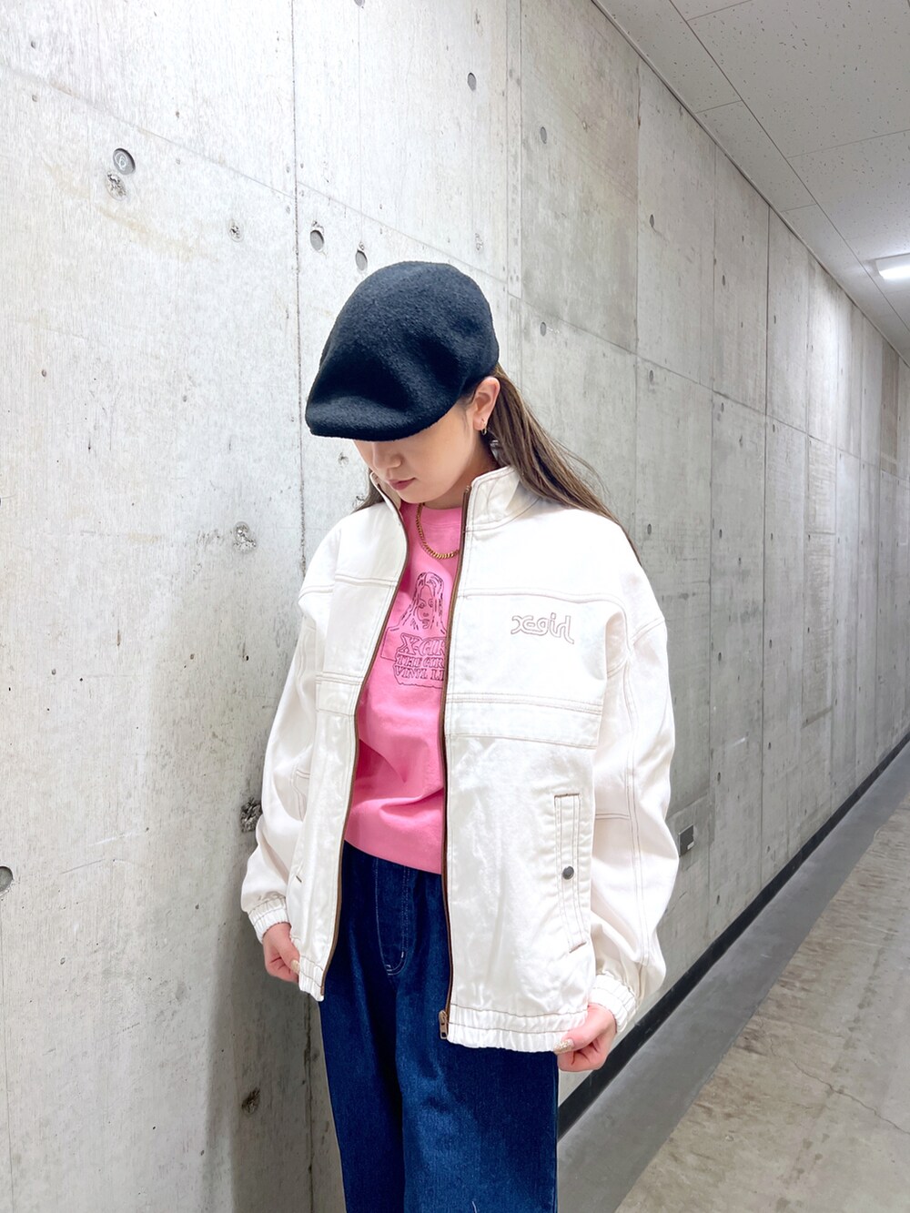 ホワイト系のブルゾン、ピンク系のTシャツ/カットソー、ブルー系のデニムパンツを着用したレディースの冬コーディネートの4枚目の写真