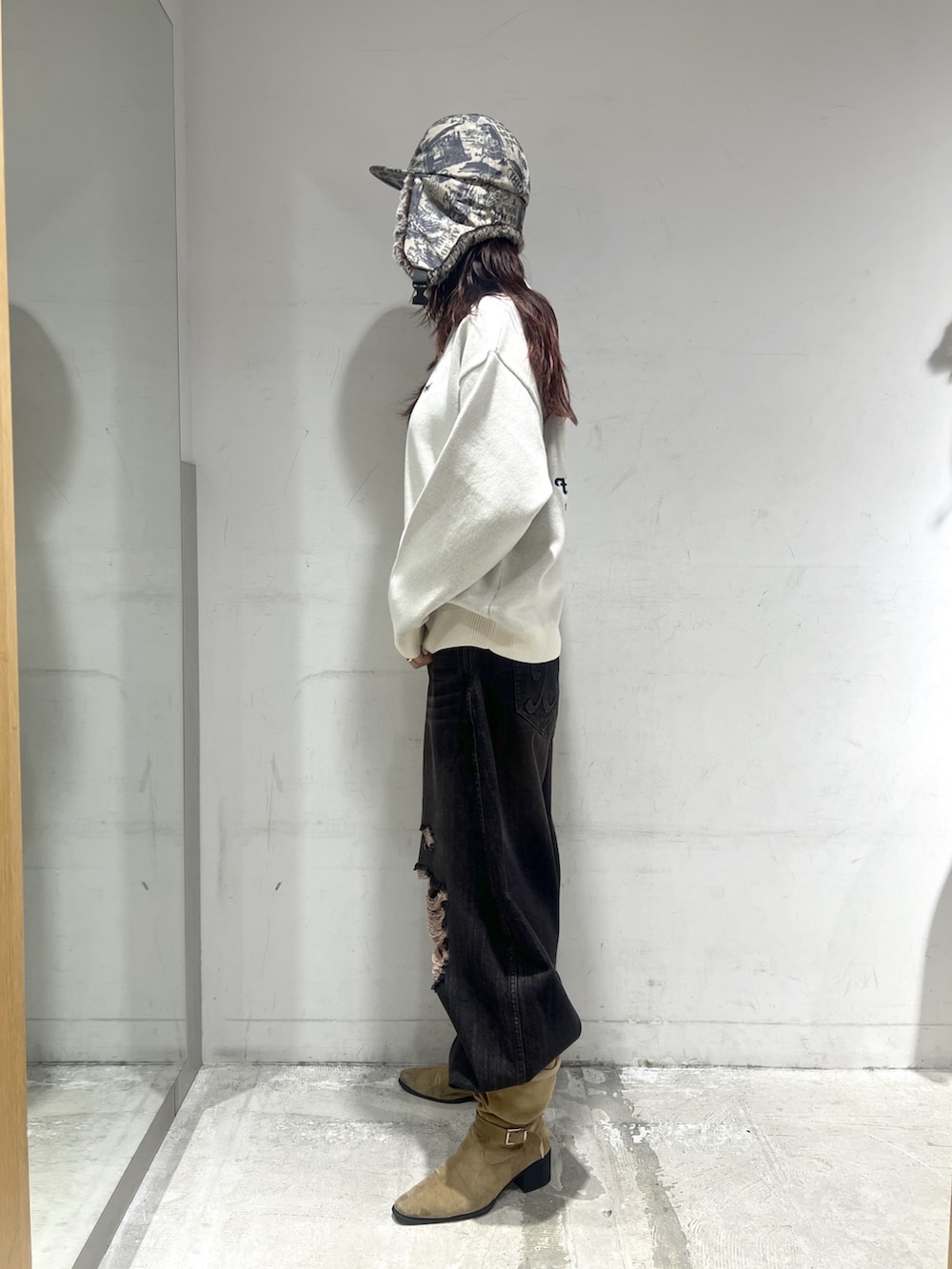 ブラック系のデニムパンツ、ホワイト系のニット/セーター、その他のキャップを着用したレディースの秋コーディネートの3枚目の写真