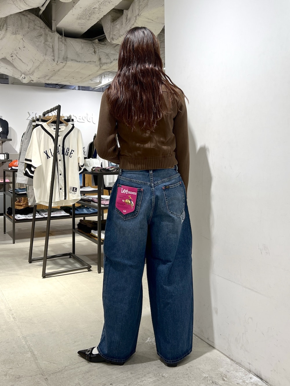 ブルー系のデニムパンツ、ブラウン系のブルゾンを着用したレディースの夏コーディネートの3枚目の写真