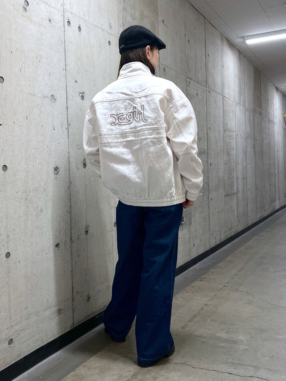 ホワイト系のブルゾン、ピンク系のTシャツ/カットソー、ブルー系のデニムパンツを着用したレディースの冬コーディネートの3枚目の写真