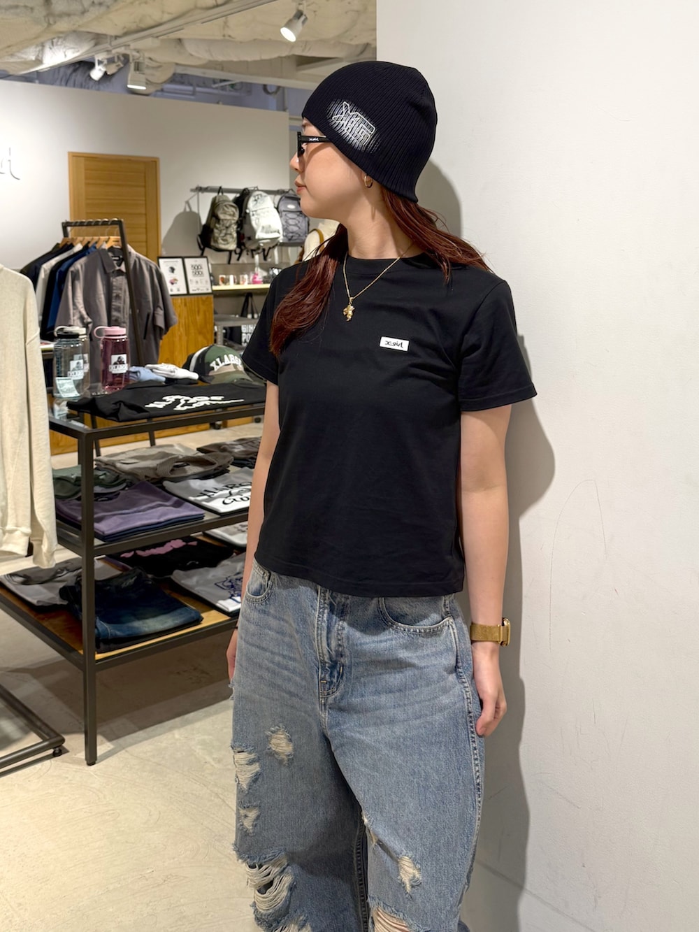 ブラック系のTシャツ/カットソー、ブルー系のデニムパンツ、ブラック系のニットキャップ/ビーニーを着用したレディースの夏コーディネートの6枚目の写真