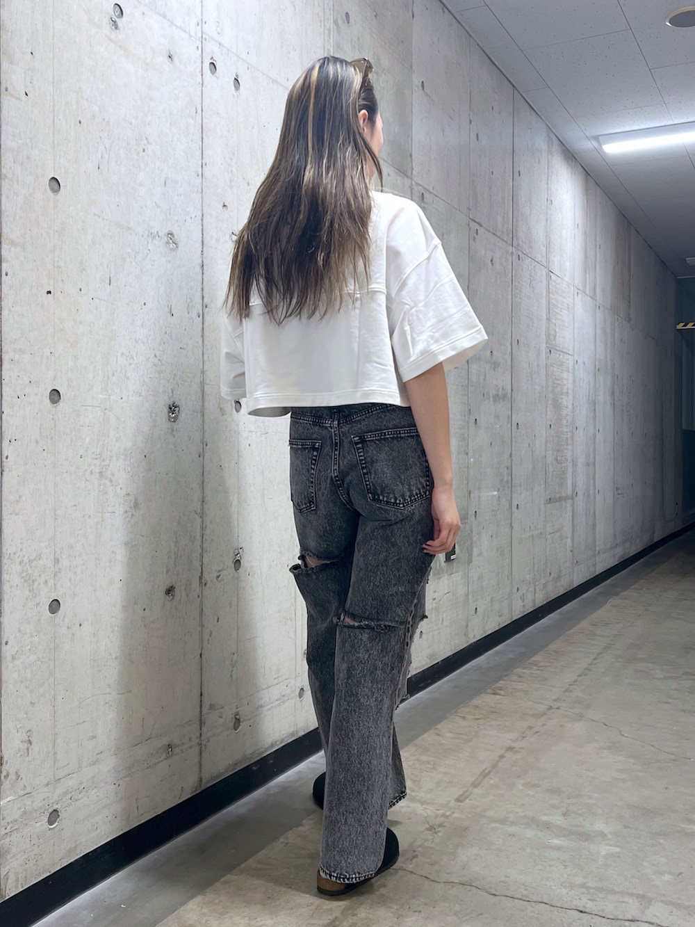 ブラック系のデニムパンツ、ホワイト系のTシャツ/カットソーを着用したレディースの春コーディネートの3枚目の写真