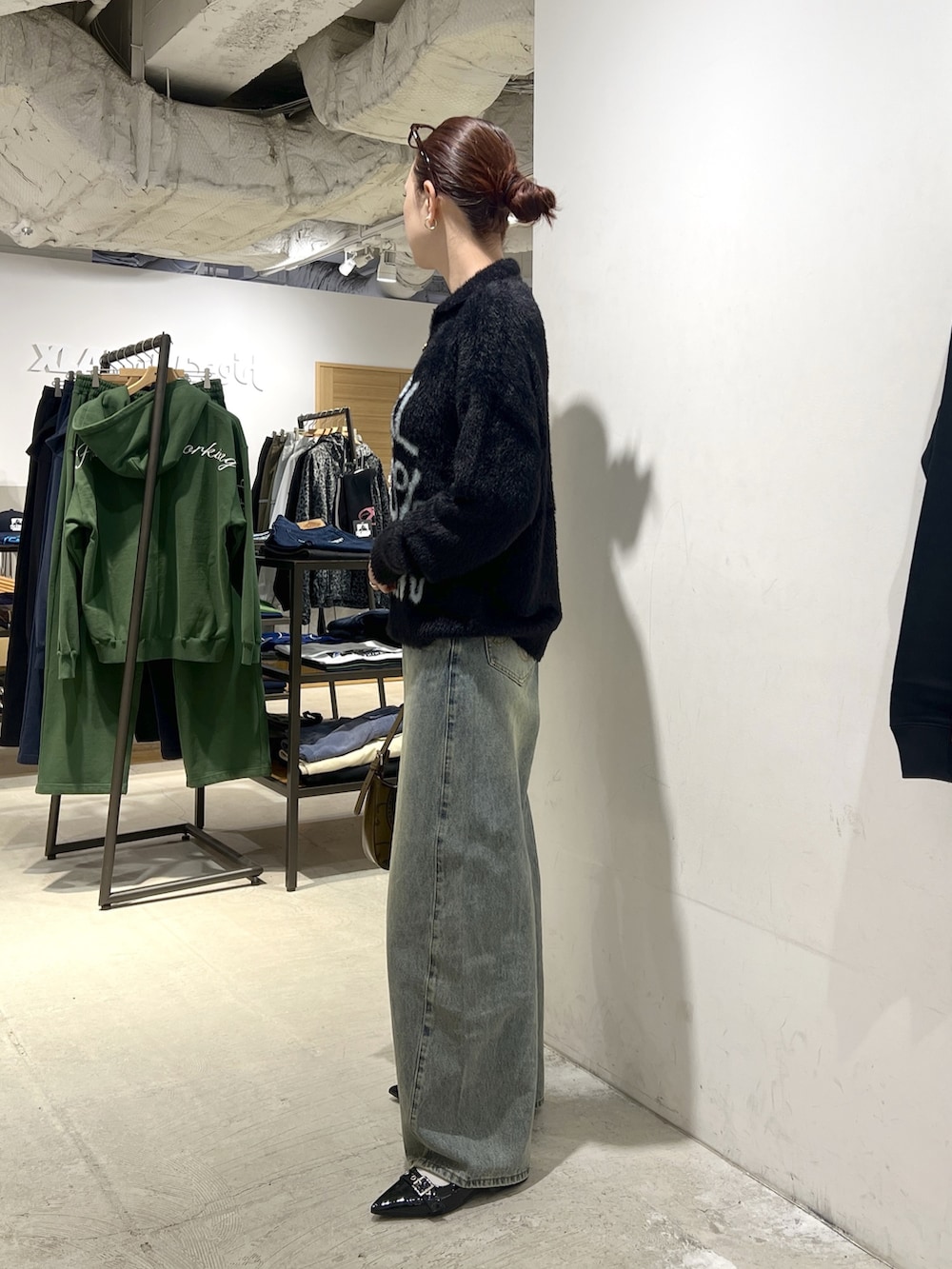 ブラック系のニット/セーター、ブルー系のデニムパンツを着用したレディースの秋コーディネートの2枚目の写真