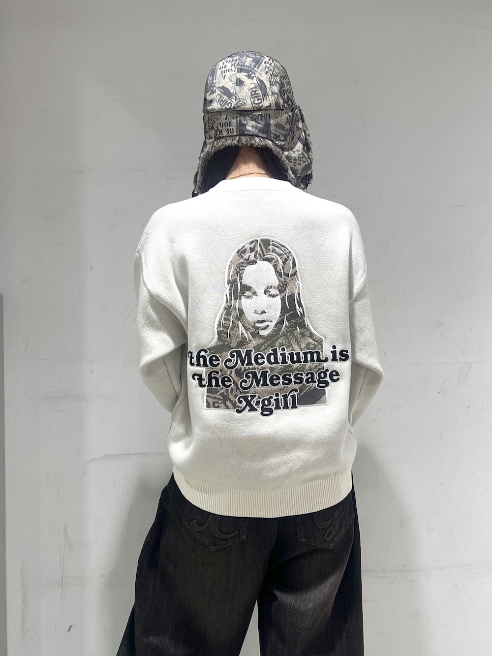 ブラック系のデニムパンツ、ホワイト系のニット/セーター、その他のキャップを着用したレディースの秋コーディネートの2枚目の写真